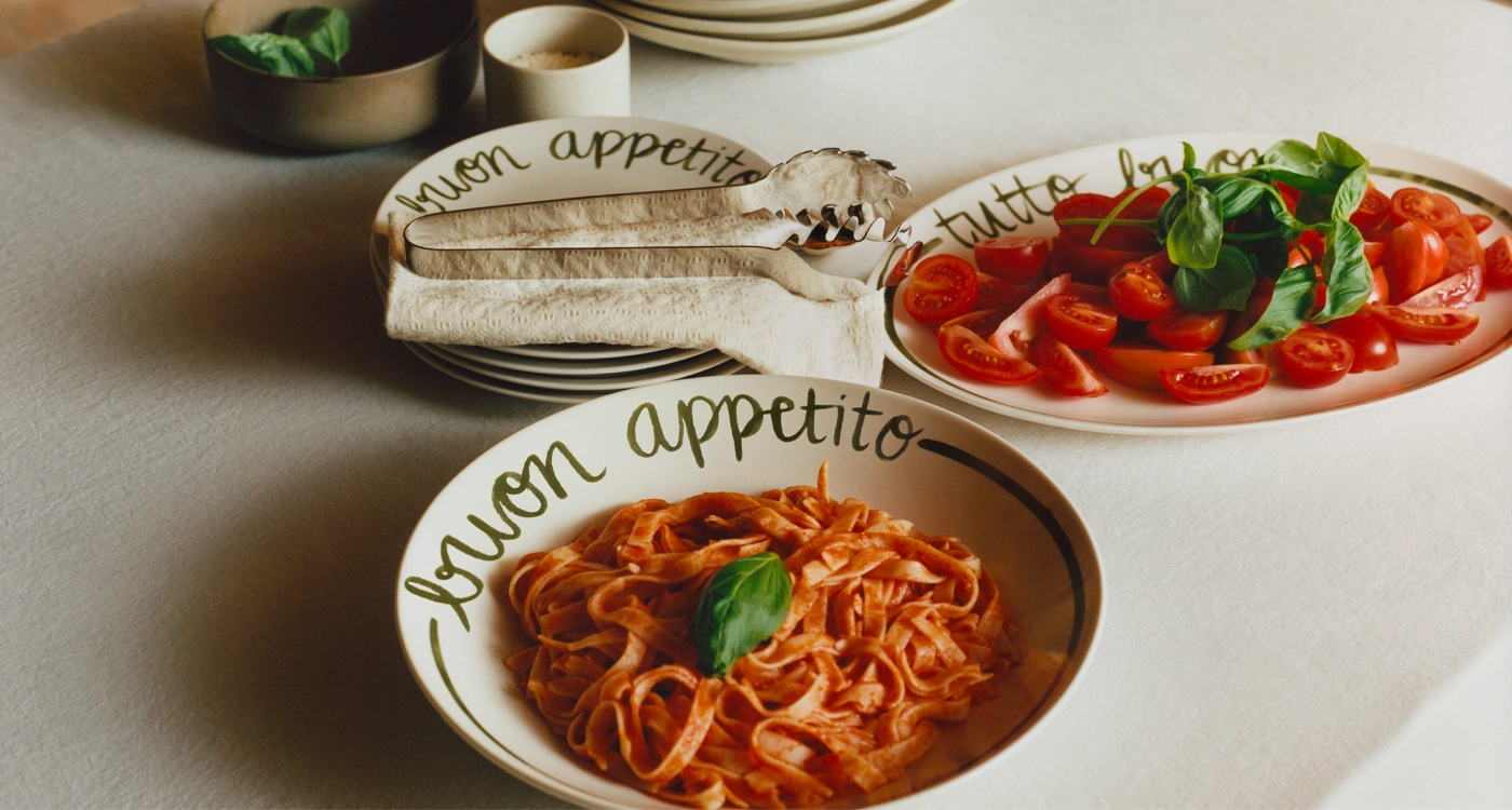 unlit living room styled with H&M HOME Spring 2026 décor in warm neutrals, soft pink accents, and mid-century inspired furniture.